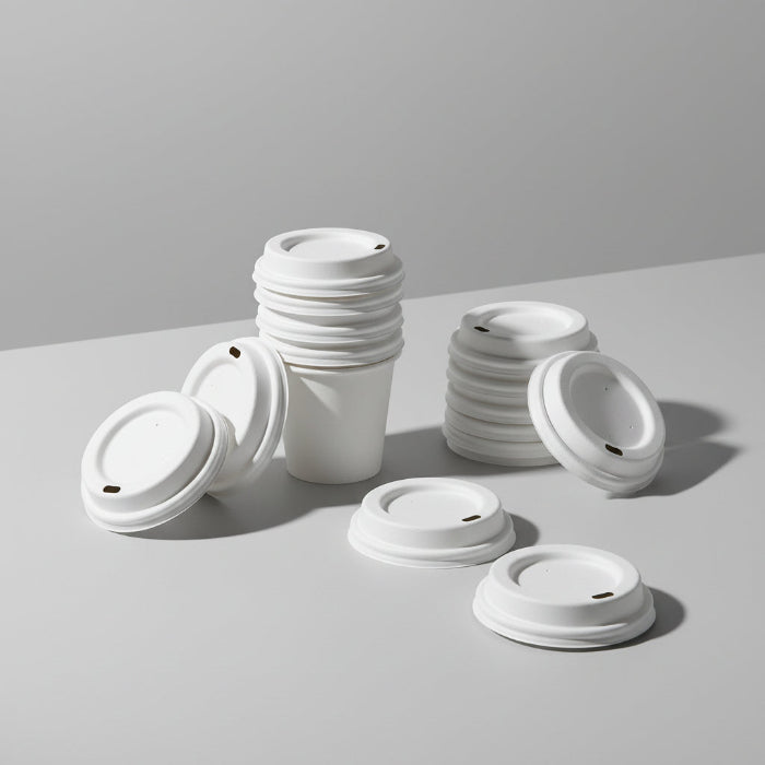 Display of sustainable sugarcane-based cup lids for coffee shops, showing their natural fiber texture and circular design